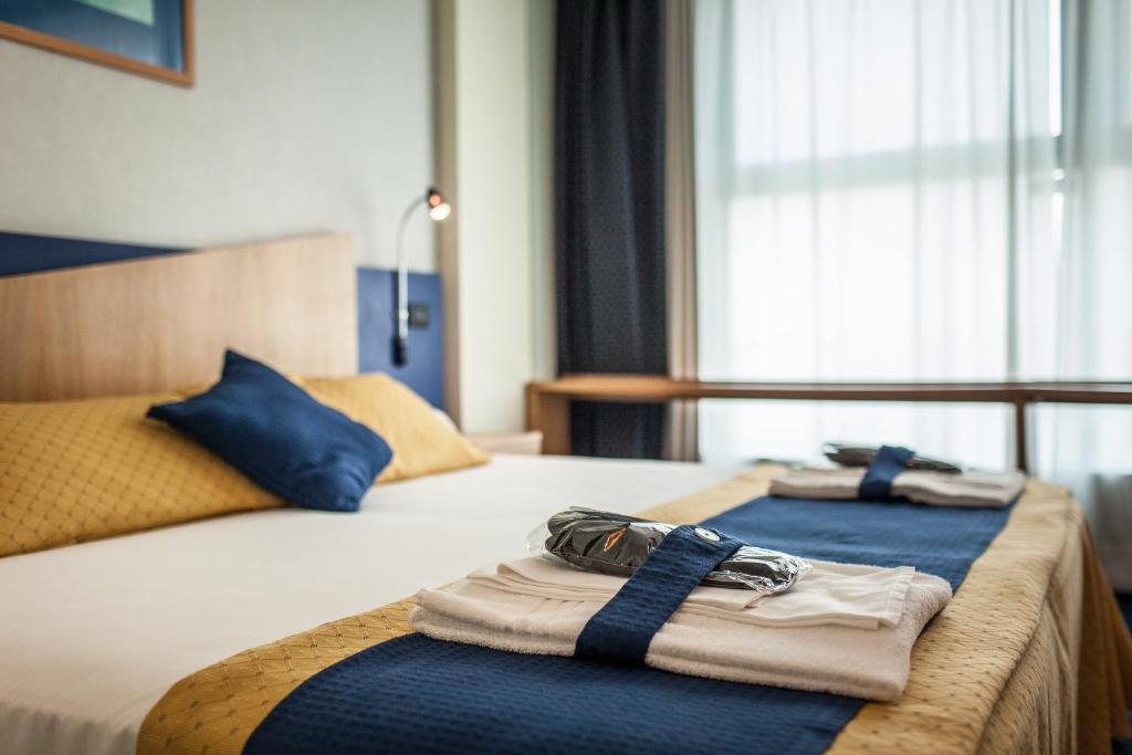 a hotel room with two beds with towels on them at Hotel Mastai in Senigallia