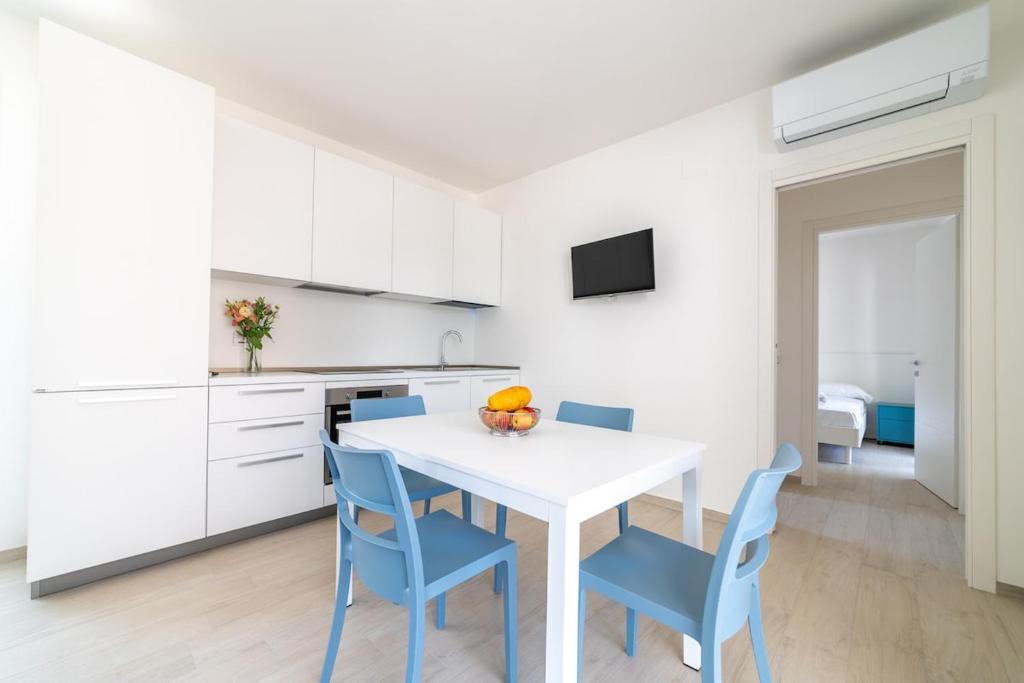 a kitchen with a white table and blue chairs at Camilla al mare in Tortoreto Lido