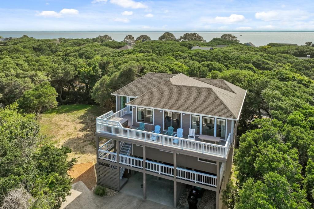 an aerial view of a house with trees and the ocean at 2444 - Sea Forever in Duck