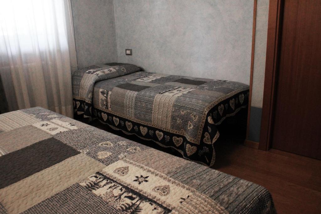 two twin beds in a small room with at B&B Leonardi in Monclassico