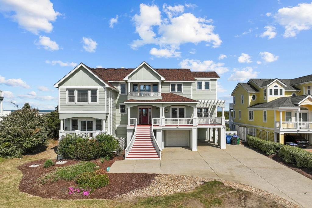 a large house with a front porch and a staircase at 4099 - 3-2-1 Relax in Duck