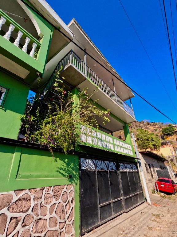 a green building with a sign on it at Casza Grande Alojamiento in La Libertad