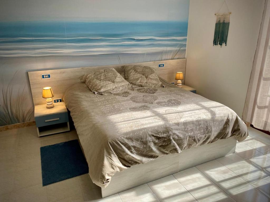 a bedroom with a bed with a painting on the wall at GinKgo B&B in Francavilla al Mare