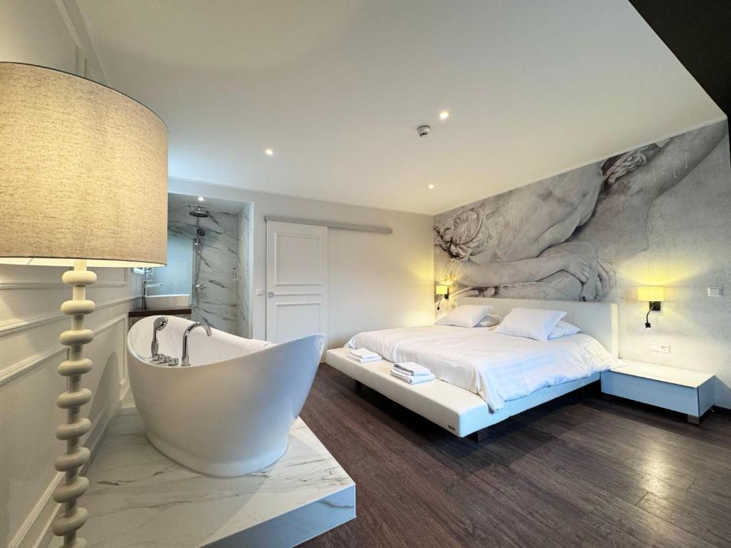a bedroom with a large bed and a bath tub at Hotel Casa Borghese in Senningerberg