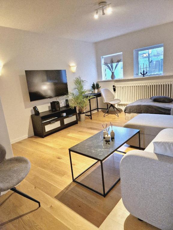 a living room with couches and a large screen tv at SelfossCenter flat in Selfoss