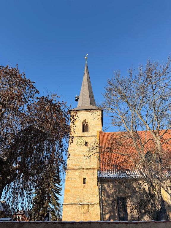 a tall building with a tower with a clock on it at Ferienwohnung Cookie in Elxleben