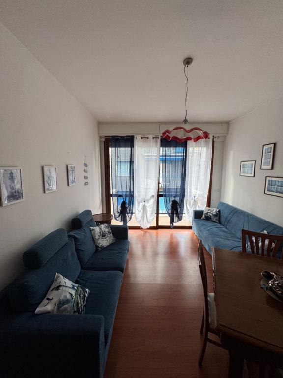a living room with a blue couch and two cats in the window at appartamento la conchiglia in Rapallo