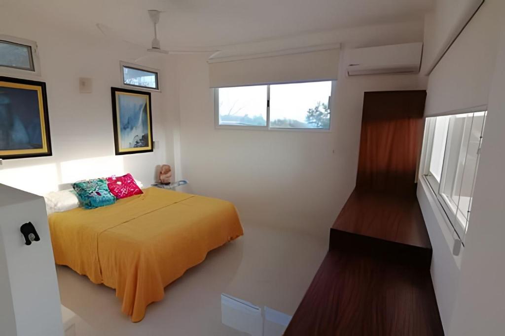 a bedroom with a bed with a yellow blanket at Valentina Salchi Bay virgin beaches fast internet in Cuatunalco
