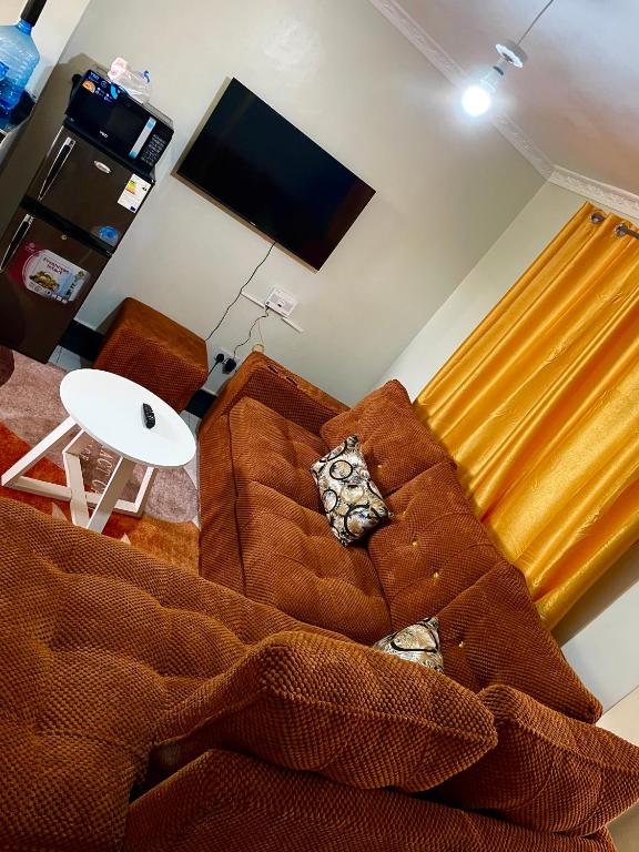 a living room with a brown couch and a table at Blissful Homes in Thika