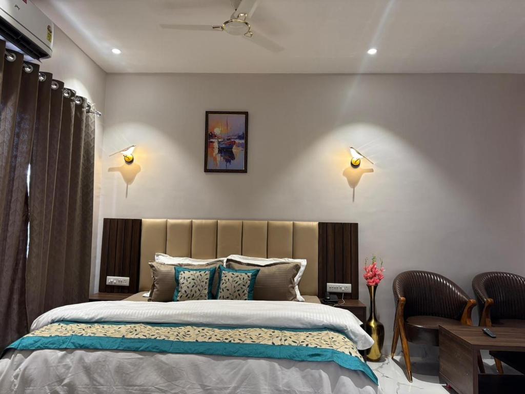 a bedroom with a large bed and two chairs at Hotel Blue Ocean in Bharweli