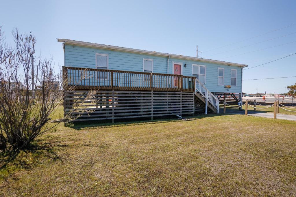 a blue house with a deck and a yard at 7022 - East Point El Dorado in Rodanthe