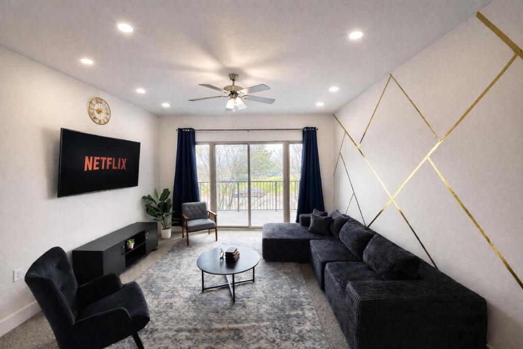 a living room with a black couch and chairs at Designer UAB Condo King Bed Balcony View 2 in Birmingham