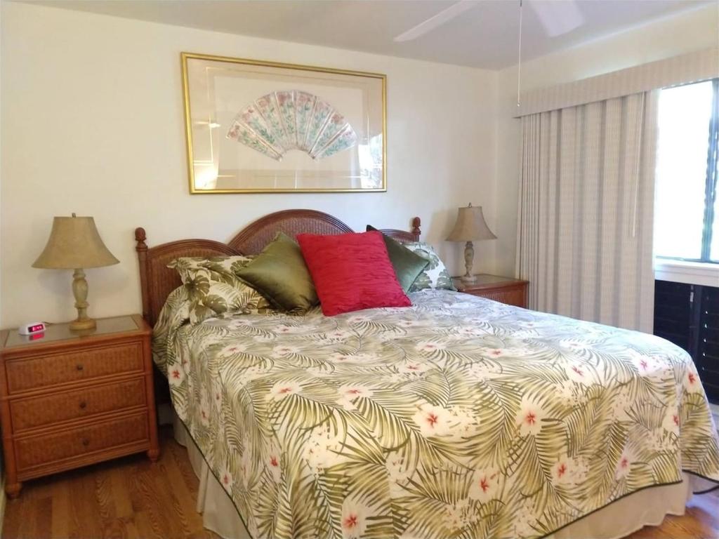 a bedroom with a bed and two lamps and a window at Unit 17 Large 1 Bed 1 Bath Condo Ocean Views in Pahala