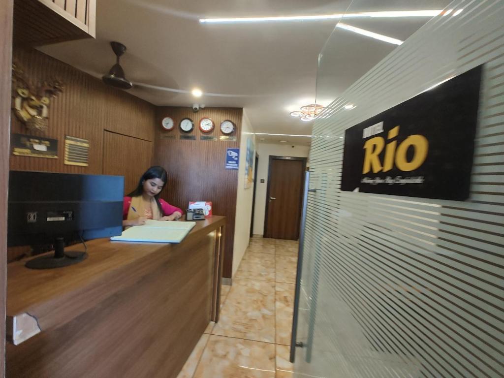 a woman sitting at a reception desk in an office at Hotel Rio in Mumbai