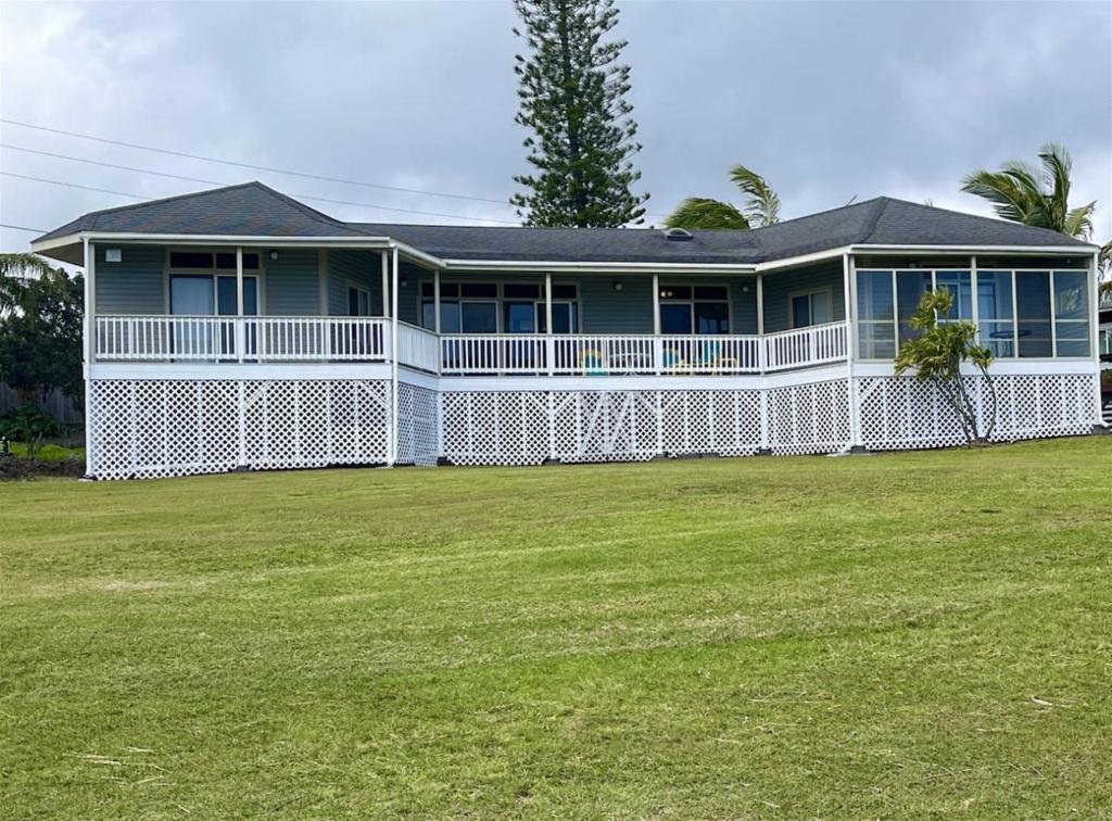 a large white house with a large yard at 2 Bedroom 2 Bath on Golf Course in Naalehu