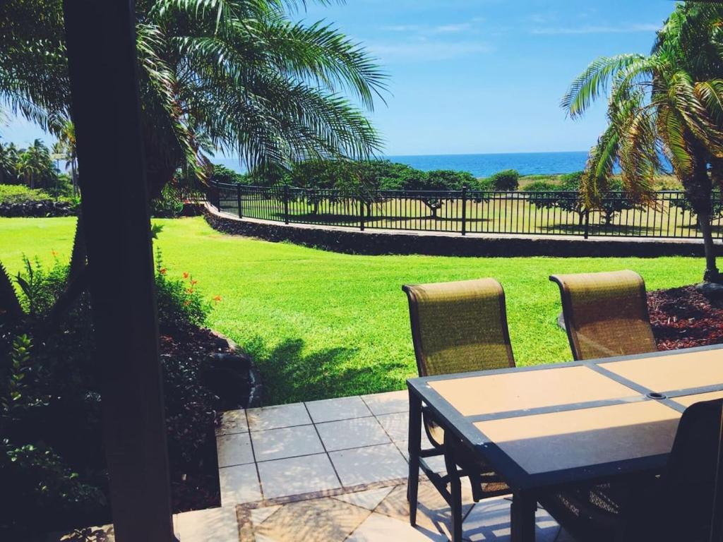 a table and chairs with a view of a lawn at 16 Two Bedroom Two Bath Condo in Pahala
