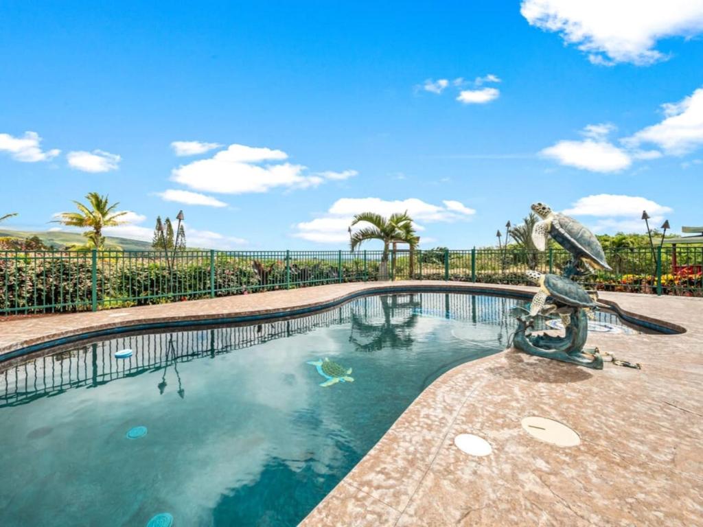 a swimming pool with a statue in the middle at Honu Harbor with Pool on Golf Course in Naalehu