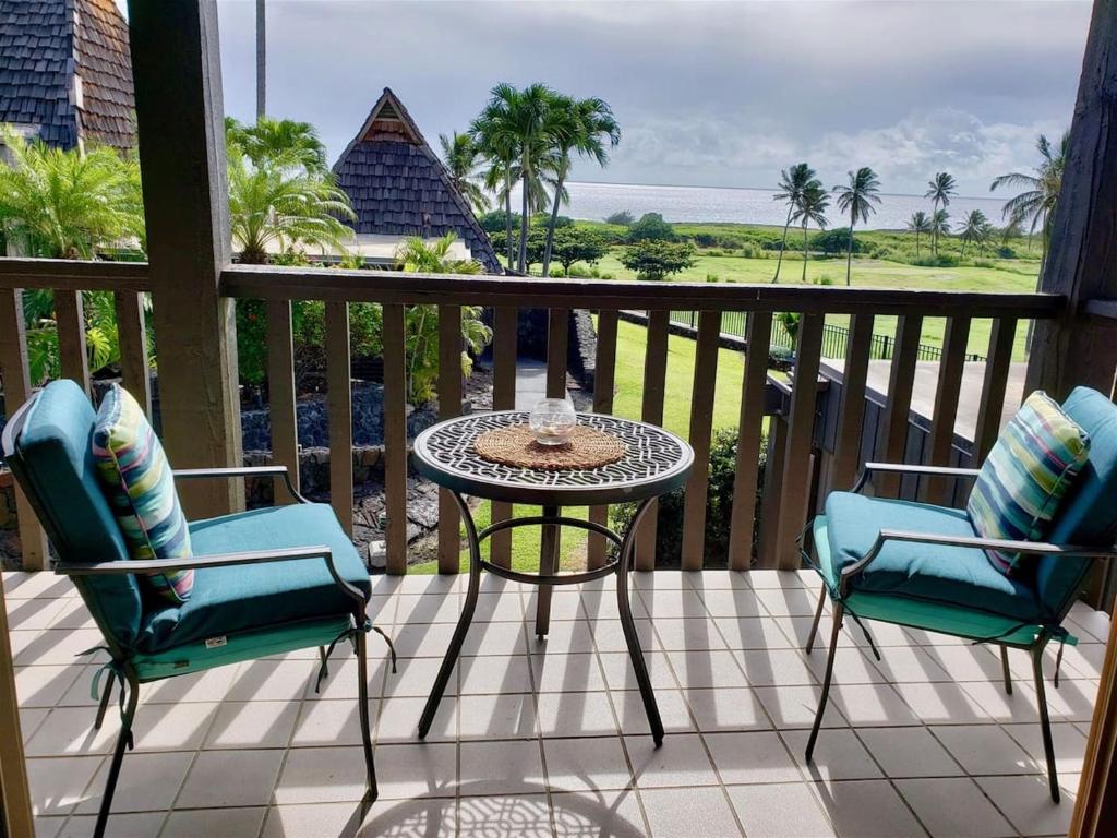 a patio with a table and chairs on a balcony at Unit 26 King Bed and Ocean View in Pahala