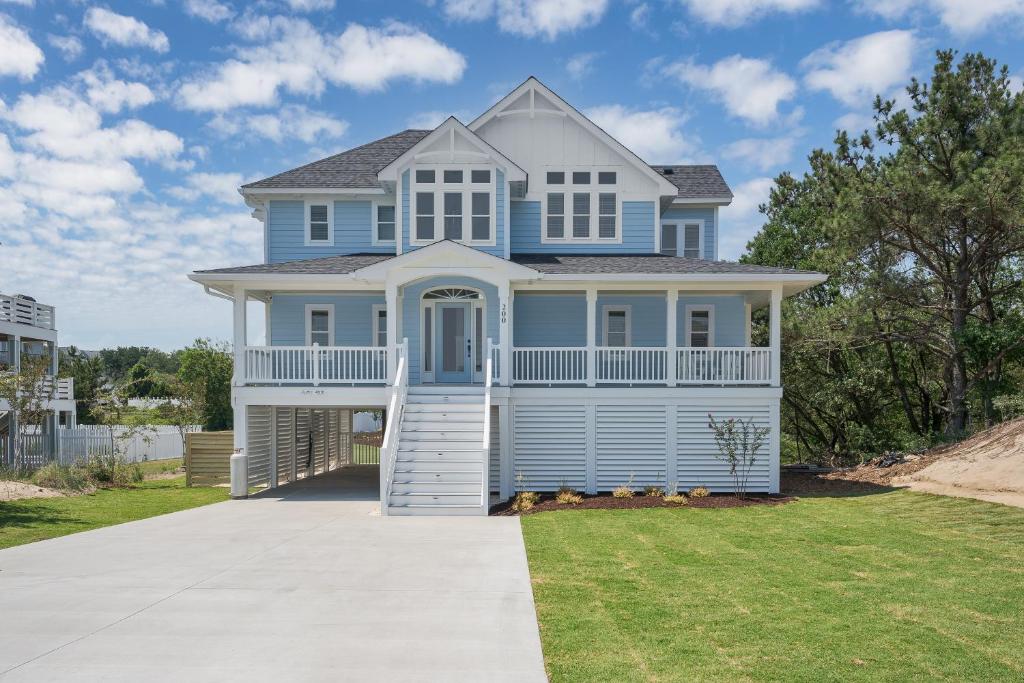 a blue house with a large driveway at 4918 - Stress Less in Kitty Hawk