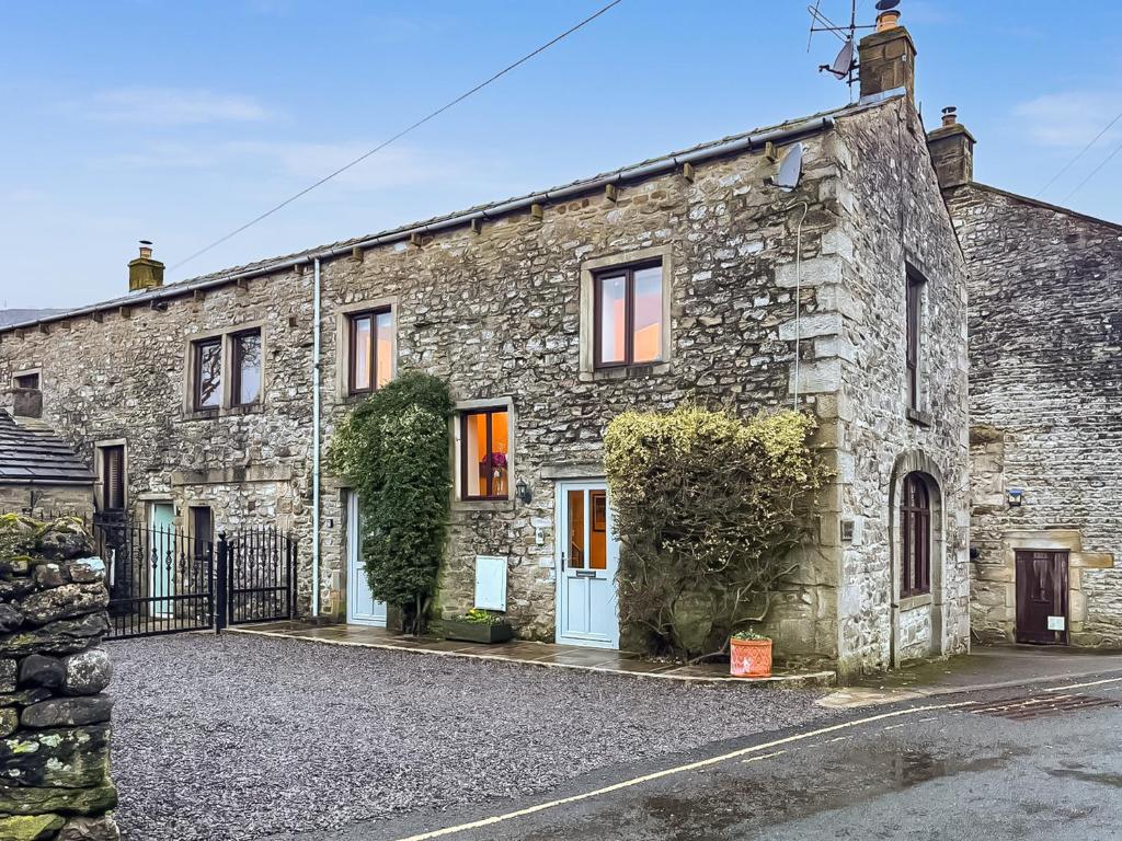an old stone house on a street at The Coach House in Kettlewell