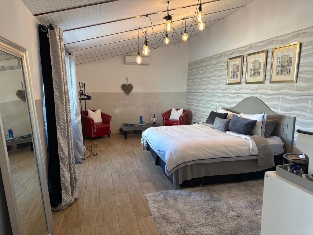 a bedroom with a large bed and a red chair at Casa Santo Antonio in Pias