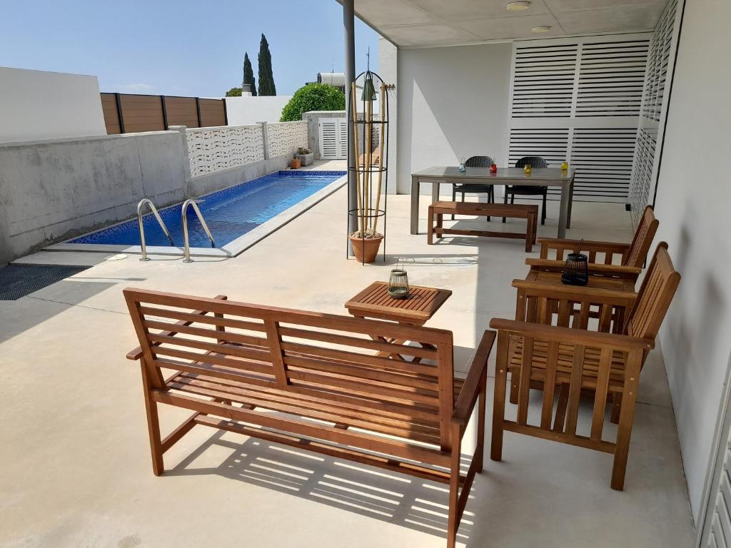 two wooden benches sitting on top of a patio at La CASA GRIS in Alcanar