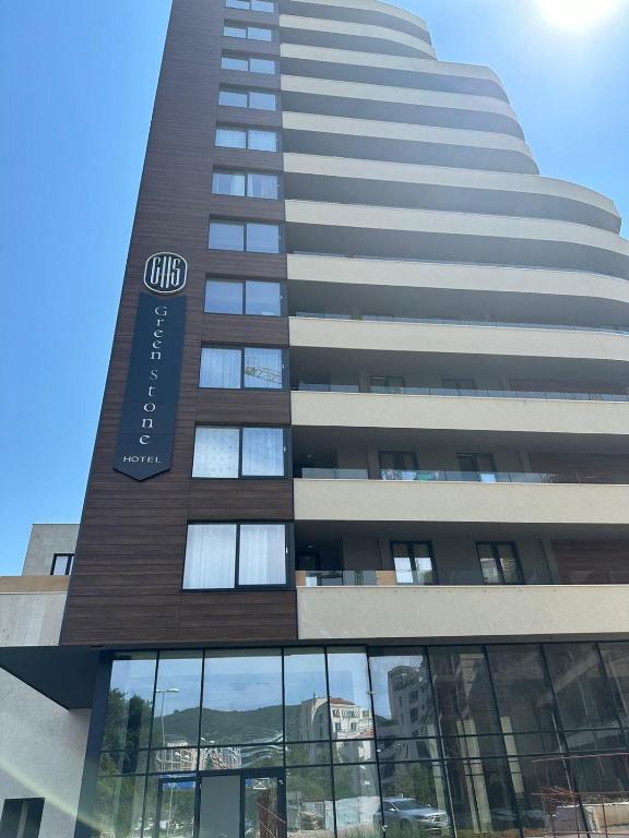 a tall building with a sign on the side of it at Green Stone lamela B in Rafailovici