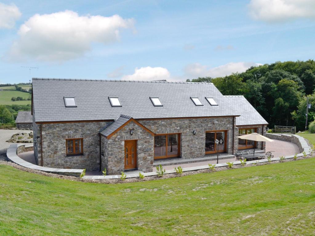 an image of a stone house with solar panels on it at The Stable - Om4 in Mydroilin