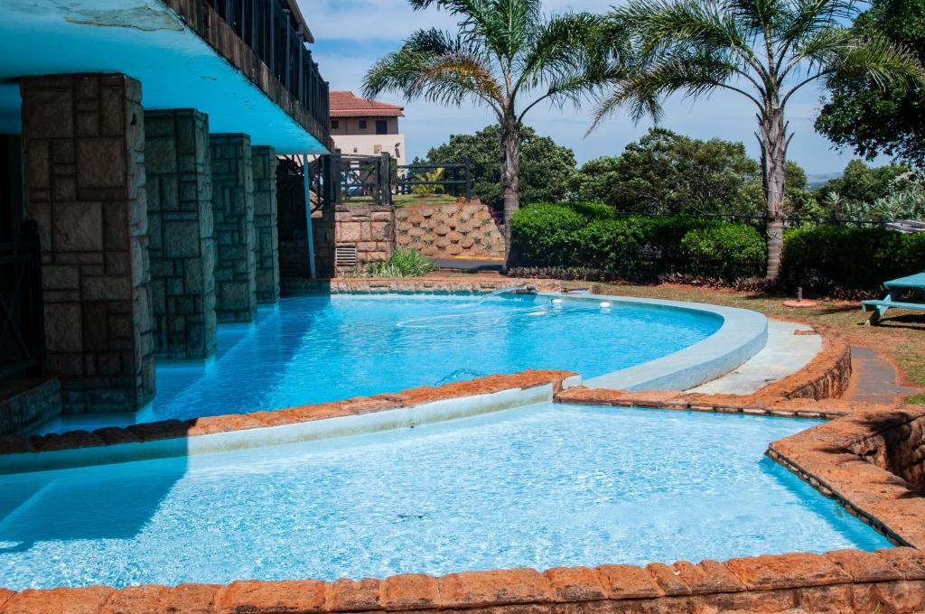 a swimming pool in a resort with blue water at Ocean View Villas B09 in Port Edward
