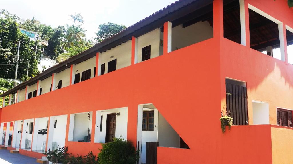 un edificio naranja y blanco con muchas ventanas en Recanto Casa de Pedrinha - Aptos para temporada e finais de semana, en Caraguatatuba