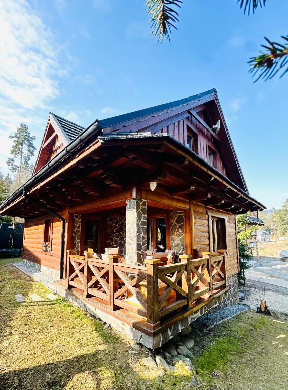 a log cabin with a wooden fence in front of it at Chata Melissa in Námestovo