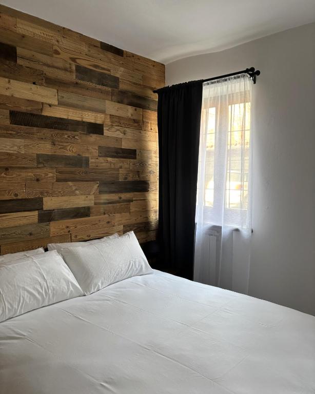 a bedroom with a white bed and a wooden wall at B&b la bessolina in Ivrea