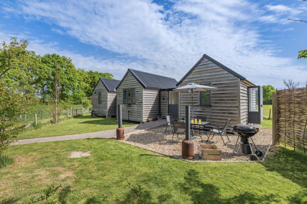 a small house with a grill in a yard at The Burrow in Biddenden