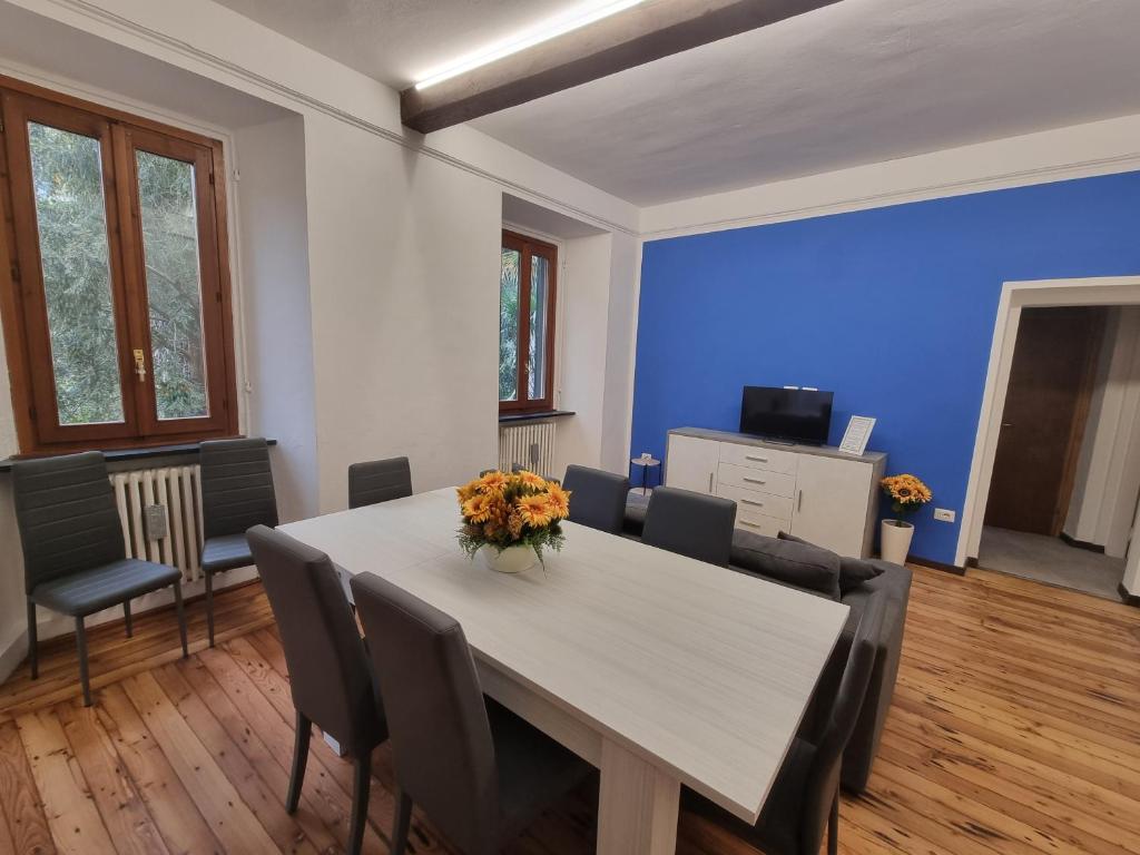a dining room with a white table and chairs at sunflower apartment in Domaso