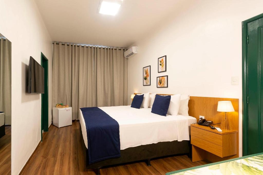 a hotel room with a bed and a television at Hotel Normandie - by Easy Hotéis in São Paulo
