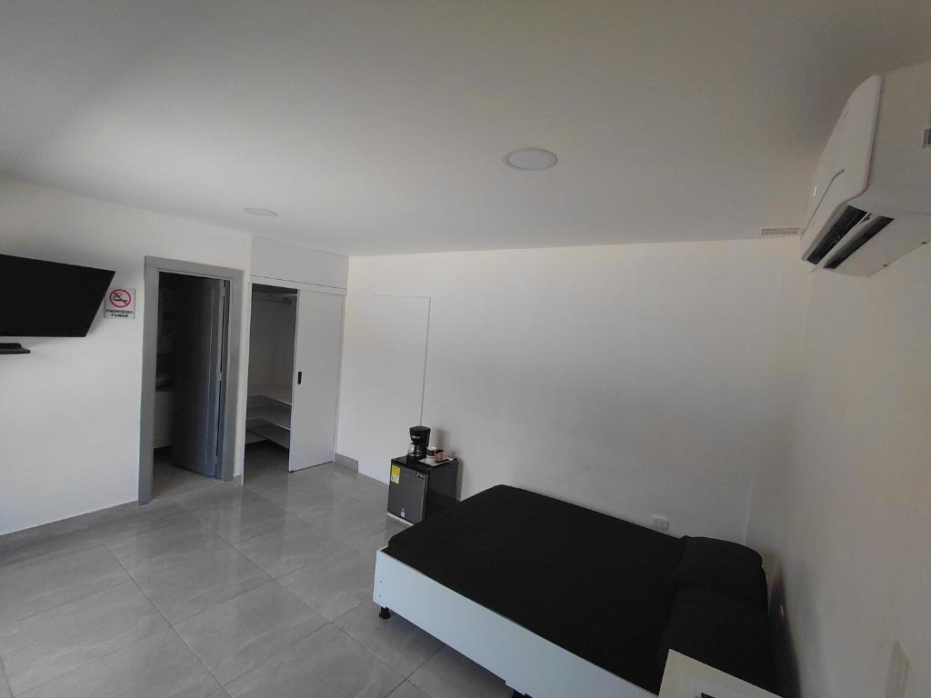 a bedroom with a black bed in a white room at San antero hospedaje in San Antero