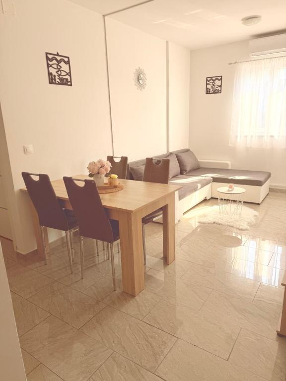 a living room with a table and chairs and a couch at Apartments Niko Novalja in Novalja