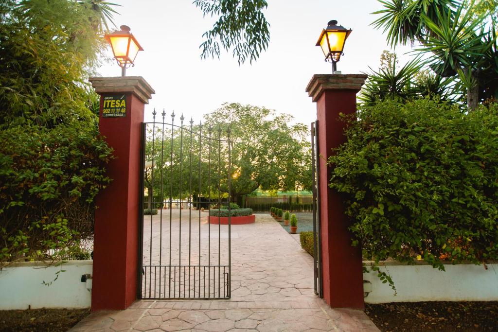 een rode poort met twee lichten erop bij Cortijo Carrillo in Cartaojal