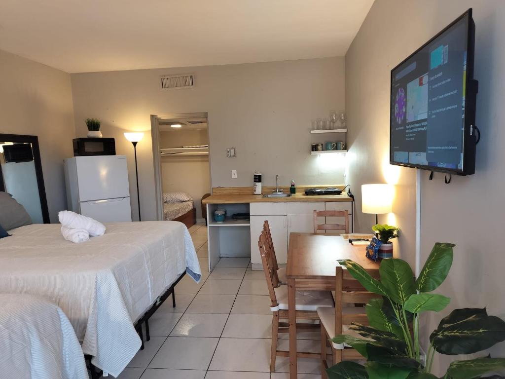 a room with two beds and a kitchen with a television at Studio in Hallandale 2270 in Hallandale Beach