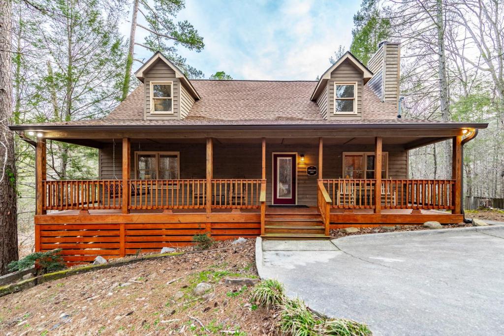 a large wooden house with a large porch at Nestled Inn in Townsend