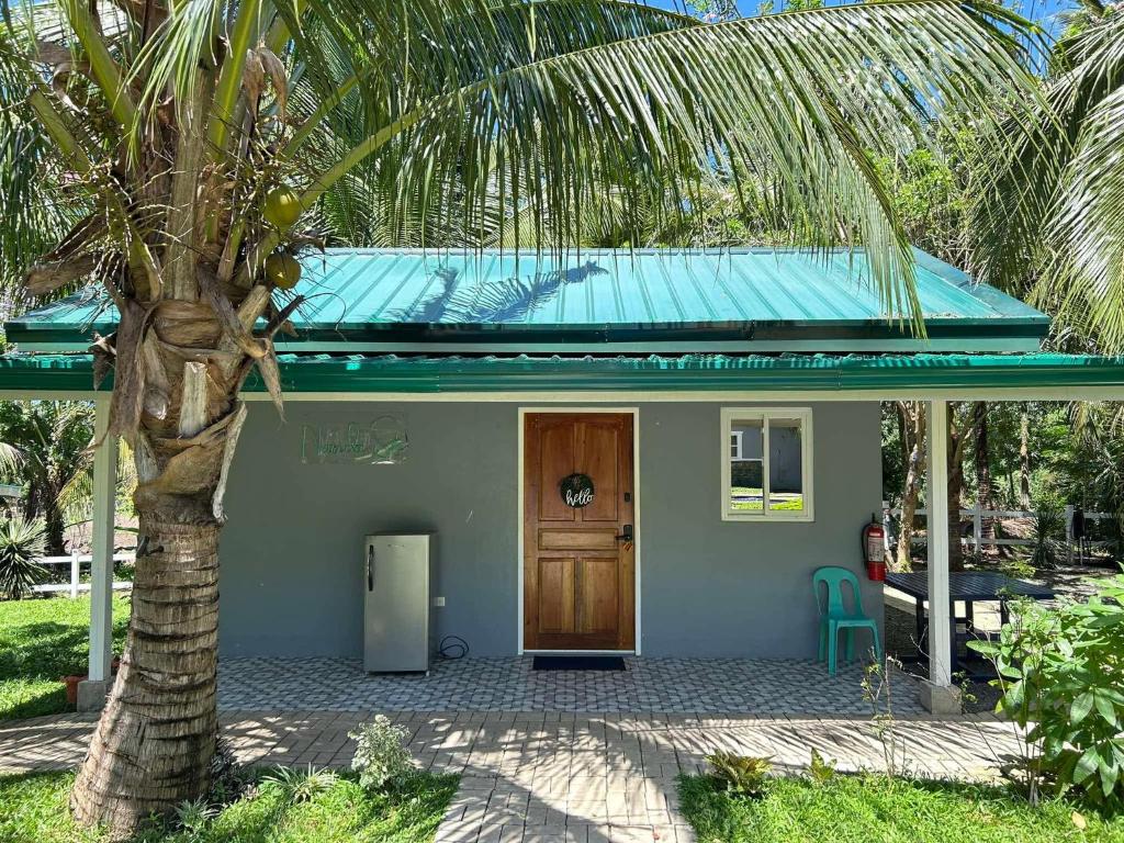 a small house with a palm tree in front of it at Starksway Resort in San Juan