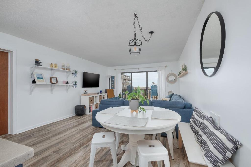 a living room with a white table and a blue couch at 2971 - Seabbatical in Duck