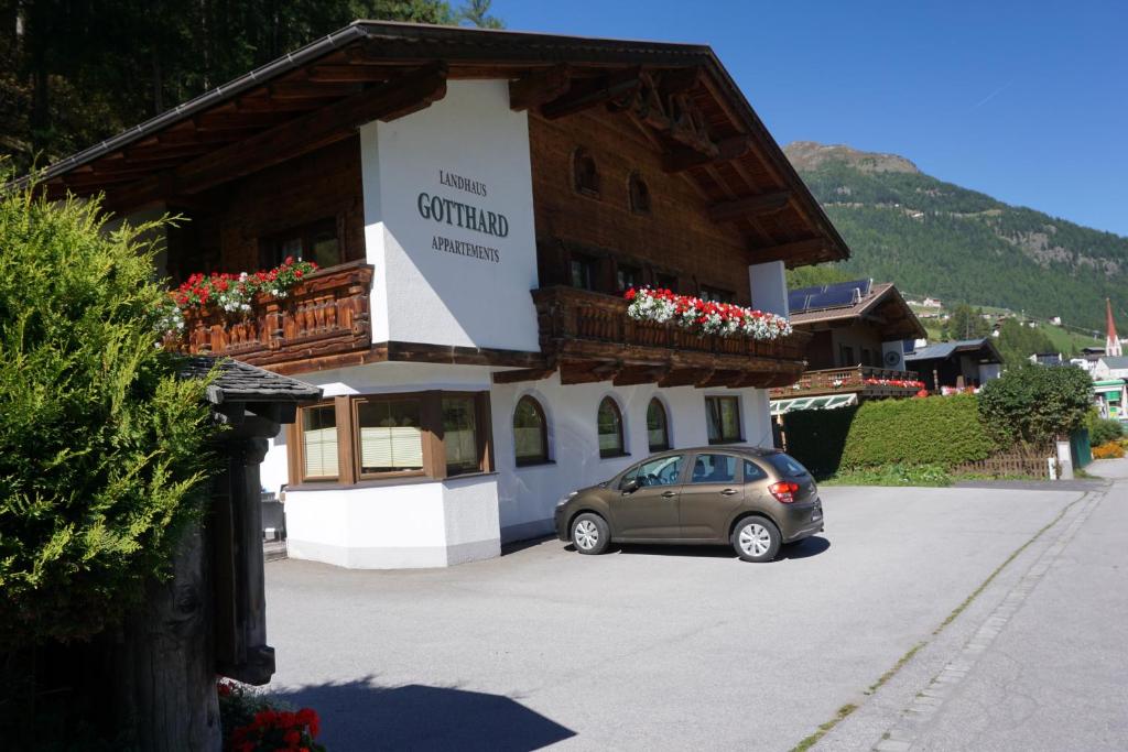 samochód zaparkowany na parkingu przed budynkiem w obiekcie Landhaus Gotthard w Solden