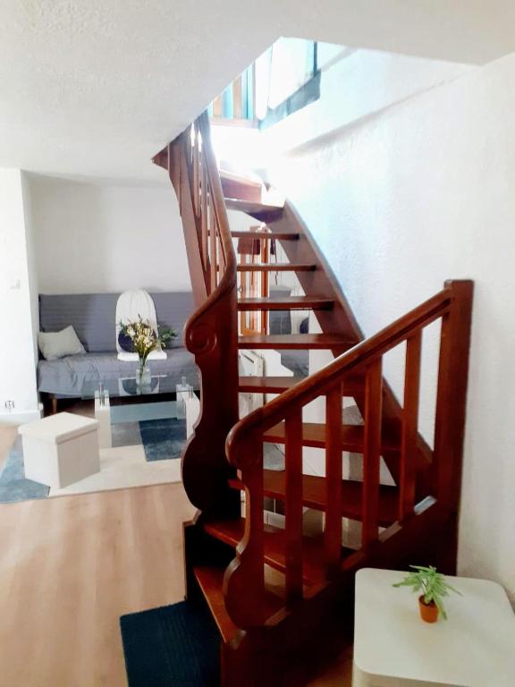 a wooden staircase in a living room with a couch at Duplex Centre historique in Strasbourg