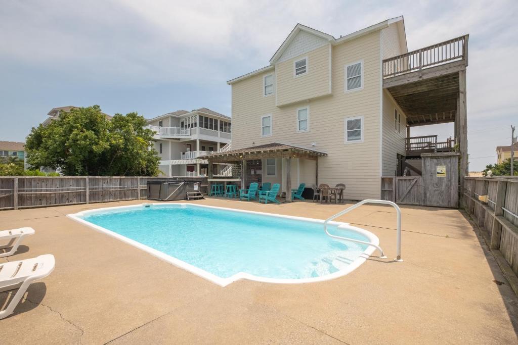 a swimming pool on a patio next to a house at 7676 - Nautical by Nature in Avon