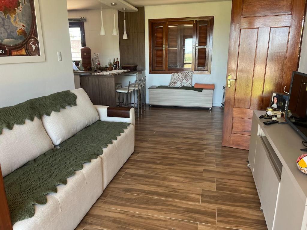 a living room with a couch and a kitchen at Comfortable home, close to everything! in Caçapava do Sul