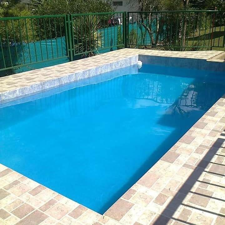 a swimming pool with blue water in a yard at La Pantera in San Antonio de Arredondo