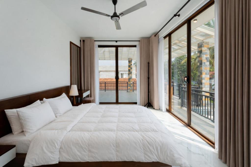 a bedroom with a large bed and a large window at Peak Heaven Apartments in Negombo