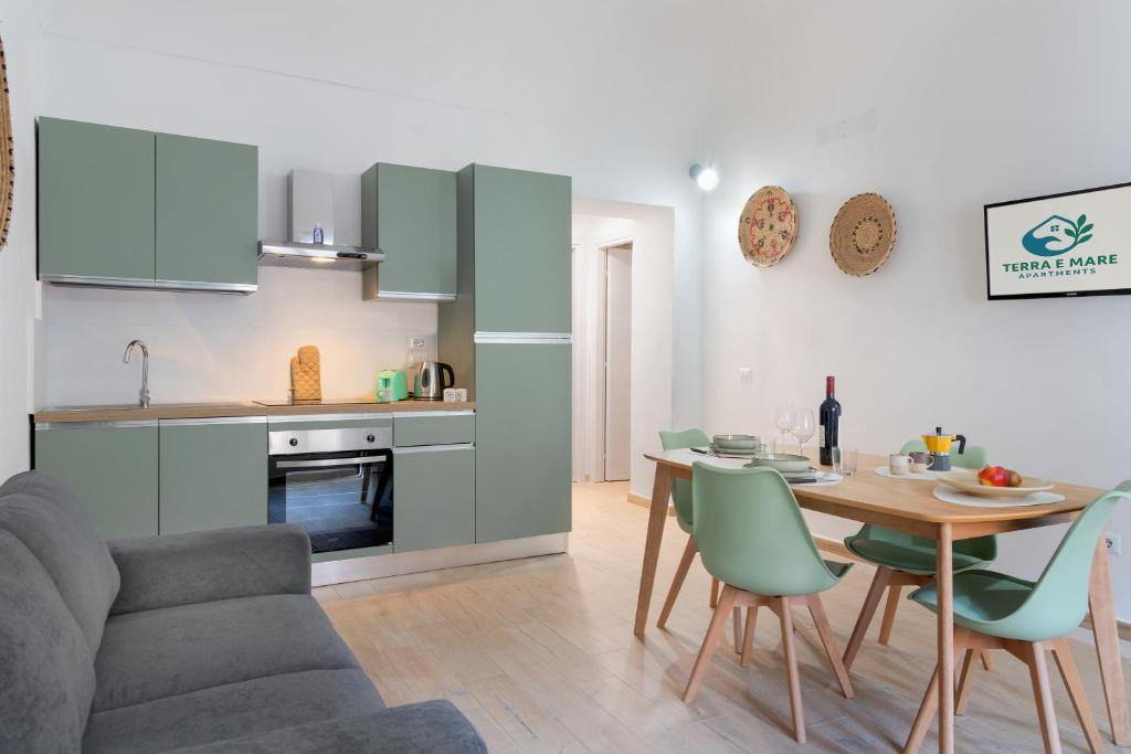 a kitchen and living room with a table and chairs at Terra e Mare Apartments II- Terra in Sorso