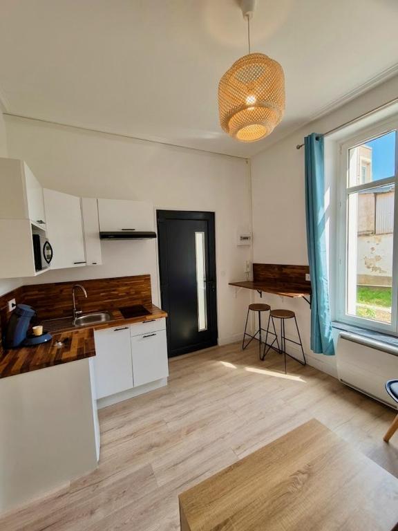 a room with a kitchen with a sink and a window at Appartement à thermal in Nancy